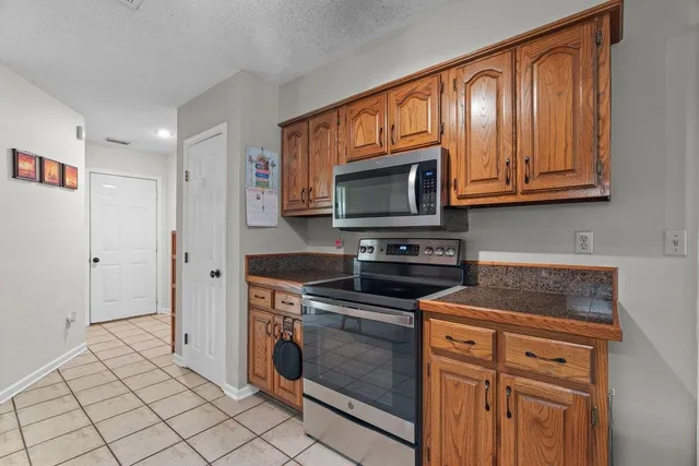 a kitchen with stainless steel appliances granite countertop a stove a microwave and a refrigerator