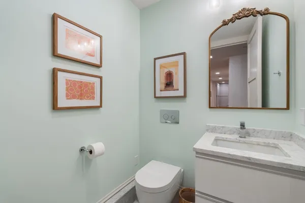 a bathroom with a toilet a sink and mirror