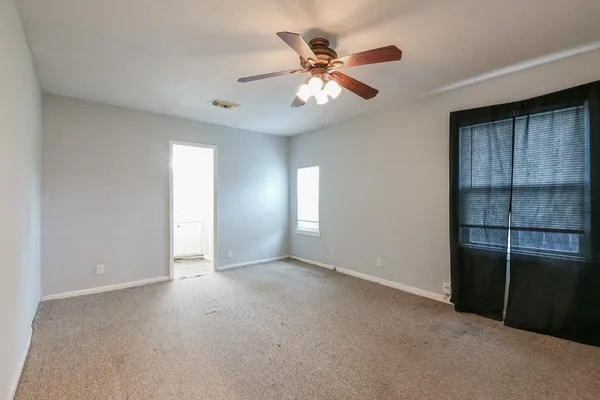 an empty room with closet and windows