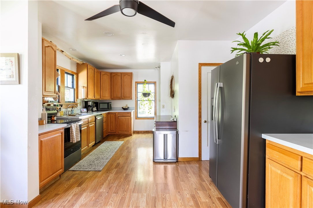 2671 Haddam Road Cleveland, OH 44120 - Photo 13 of 34 Kitchen featuring appliances with stainless steel finishes, light wood-style floors, light countertops, ceiling fan, and a sink