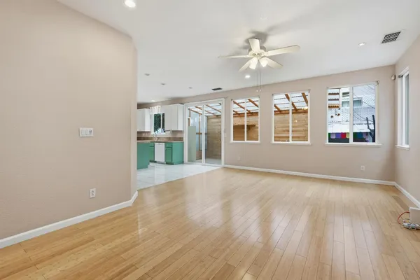 an empty room with wooden floor and windows