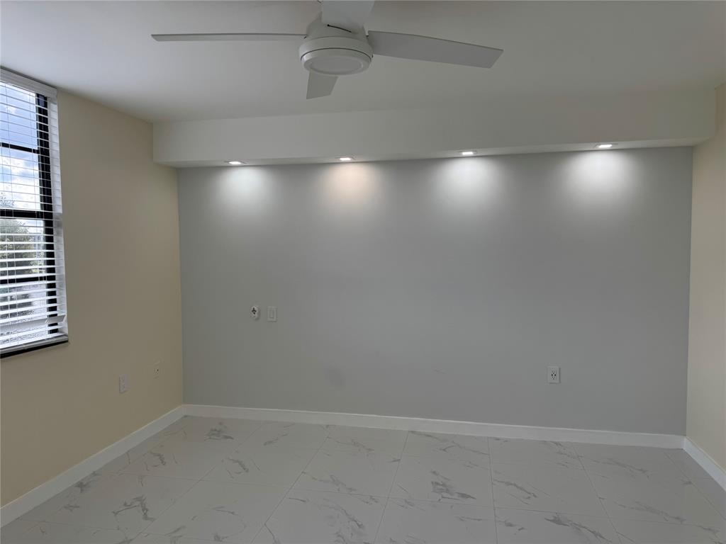 1520 Whitehall Drive, Unit 306 Davie, FL 33324 - Photo 18 of 42 an empty room with wooden floor and windows