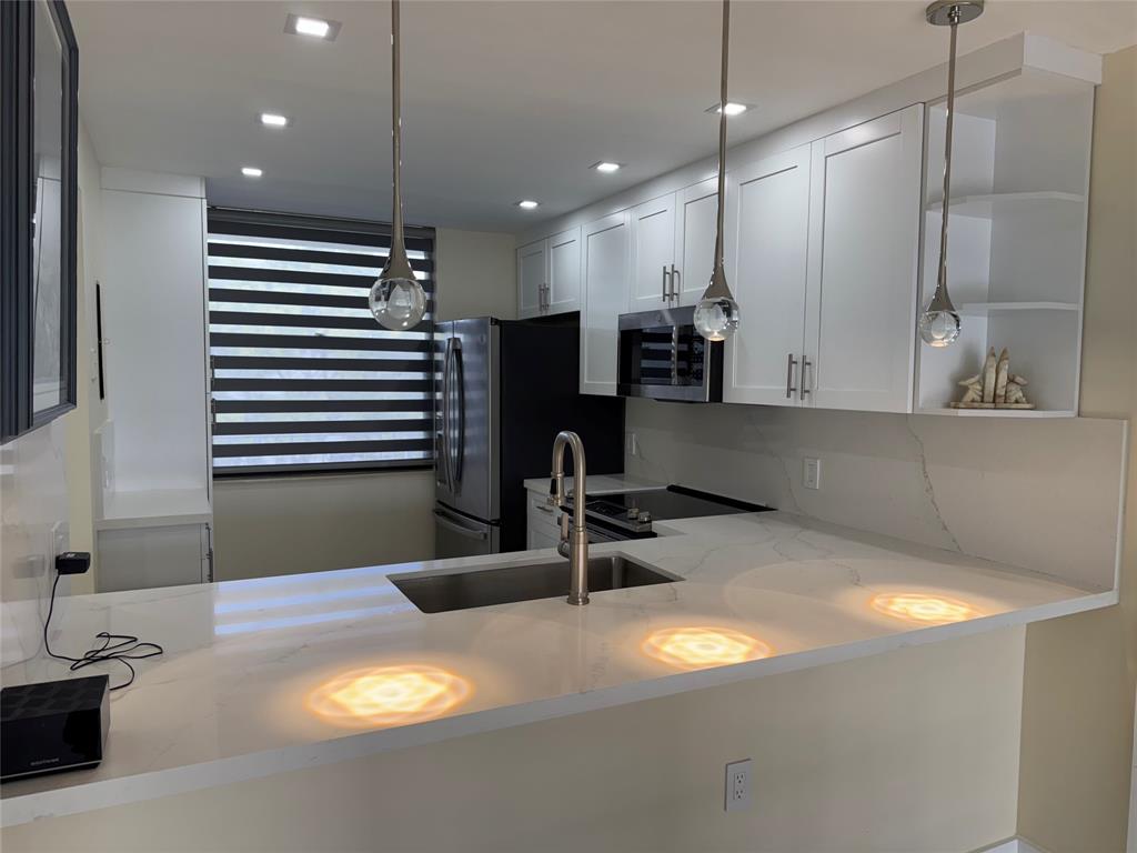 1520 Whitehall Drive, Unit 306 Davie, FL 33324 - Photo 5 of 42 a kitchen with a sink and a refrigerator