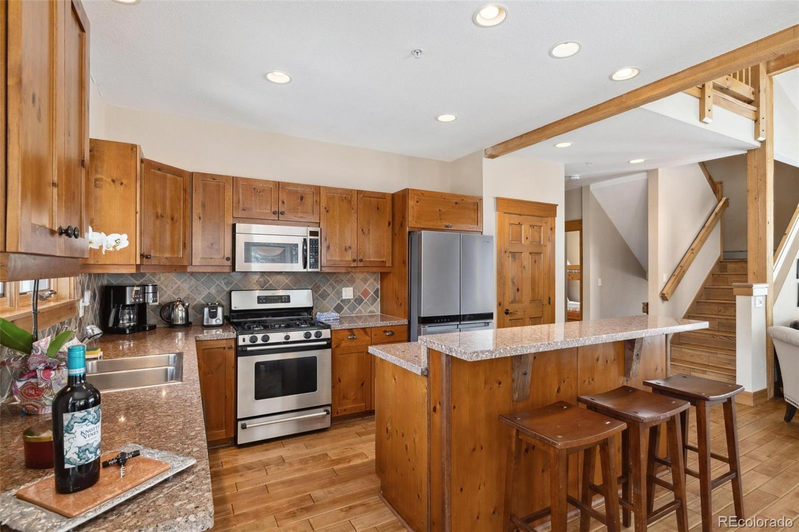129 Tip Top Trail, Unit 6543 Dillon, CO 80435 - Photo 12 of 40 a kitchen with stainless steel appliances kitchen island granite countertop a stove a sink and a refrigerator
