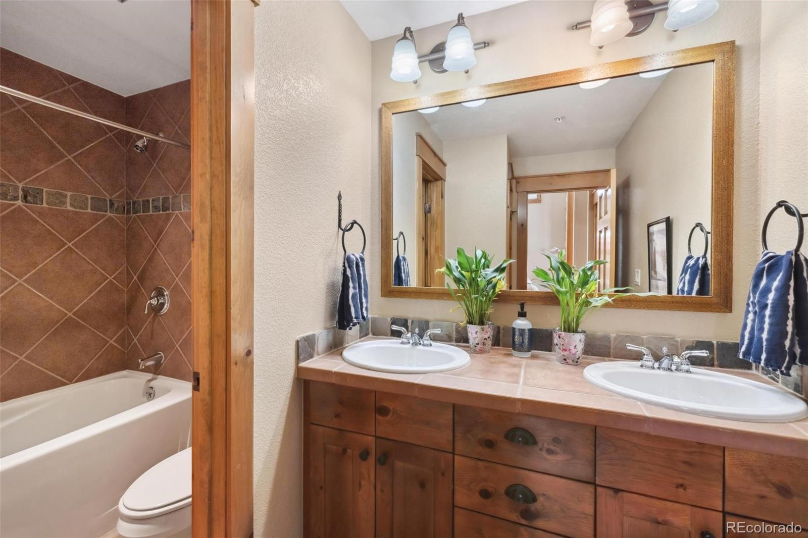 129 Tip Top Trail, Unit 6543 Dillon, CO 80435 - Photo 26 of 40 a bathroom with a double vanity sink toilet mirror and bathtub