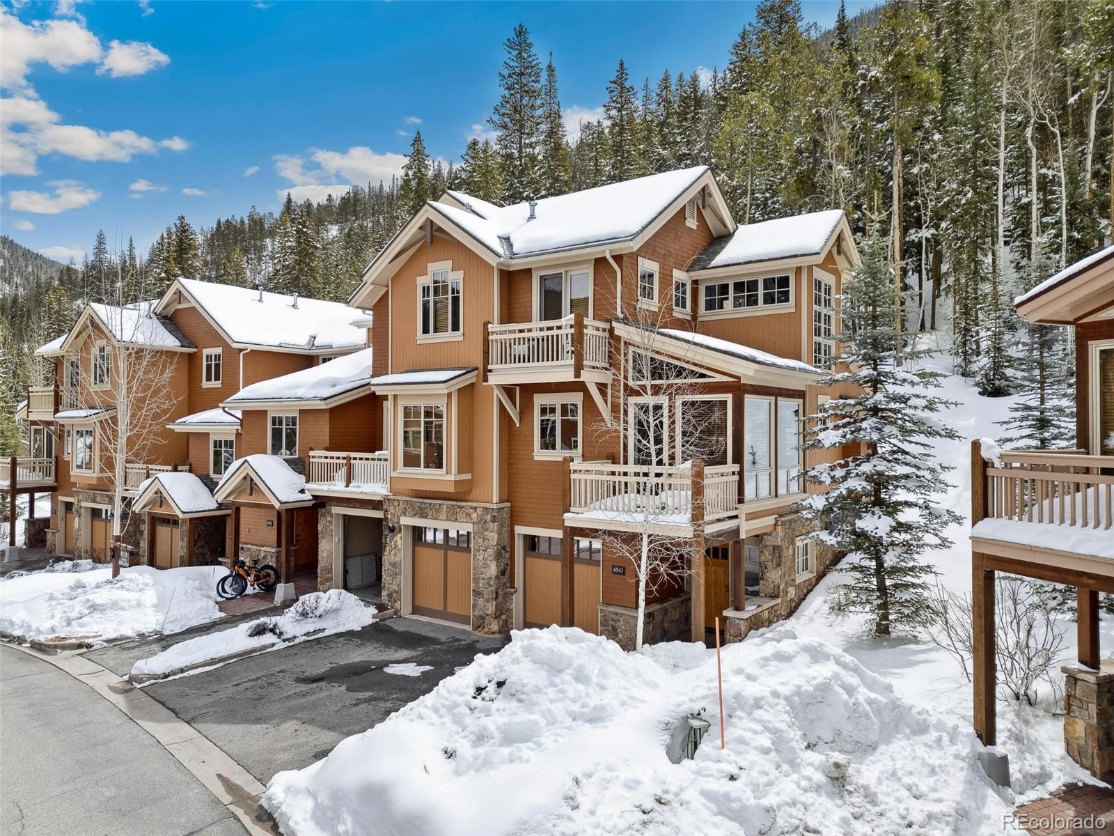 129 Tip Top Trail, Unit 6543 Dillon, CO 80435 - Photo 34 of 40 a view of a white house with large windows next to a road