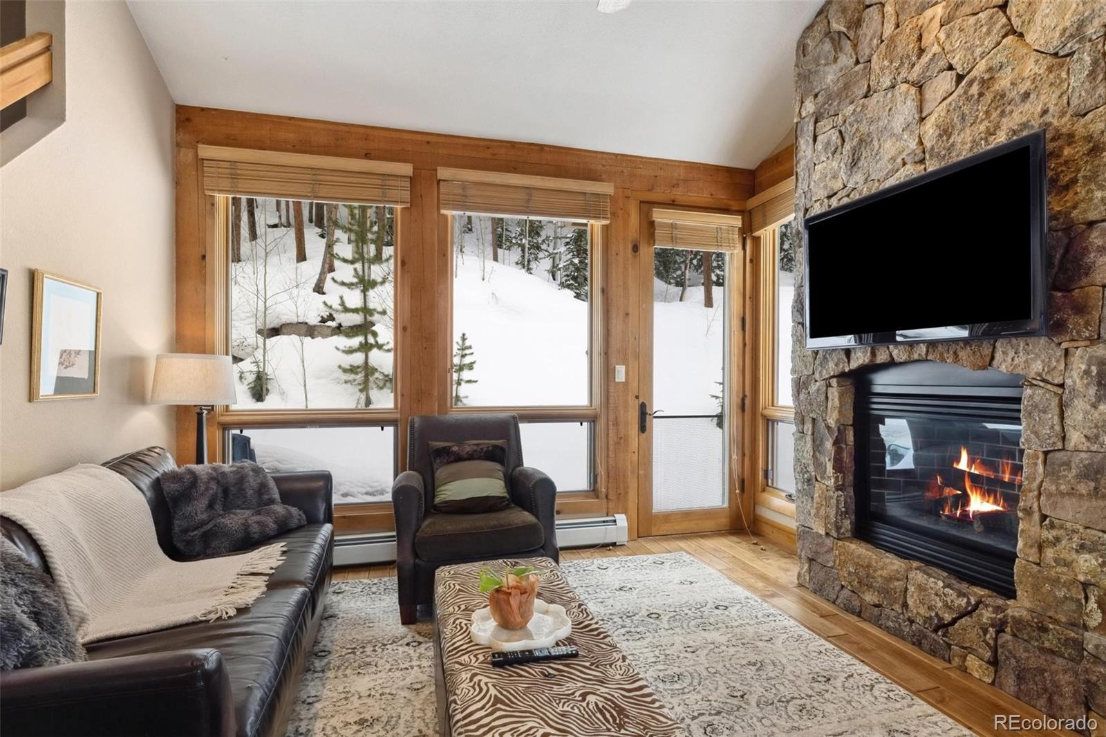 129 Tip Top Trail, Unit 6543 Dillon, CO 80435 - Photo 6 of 40 a living room with furniture a flat screen tv and a fireplace
