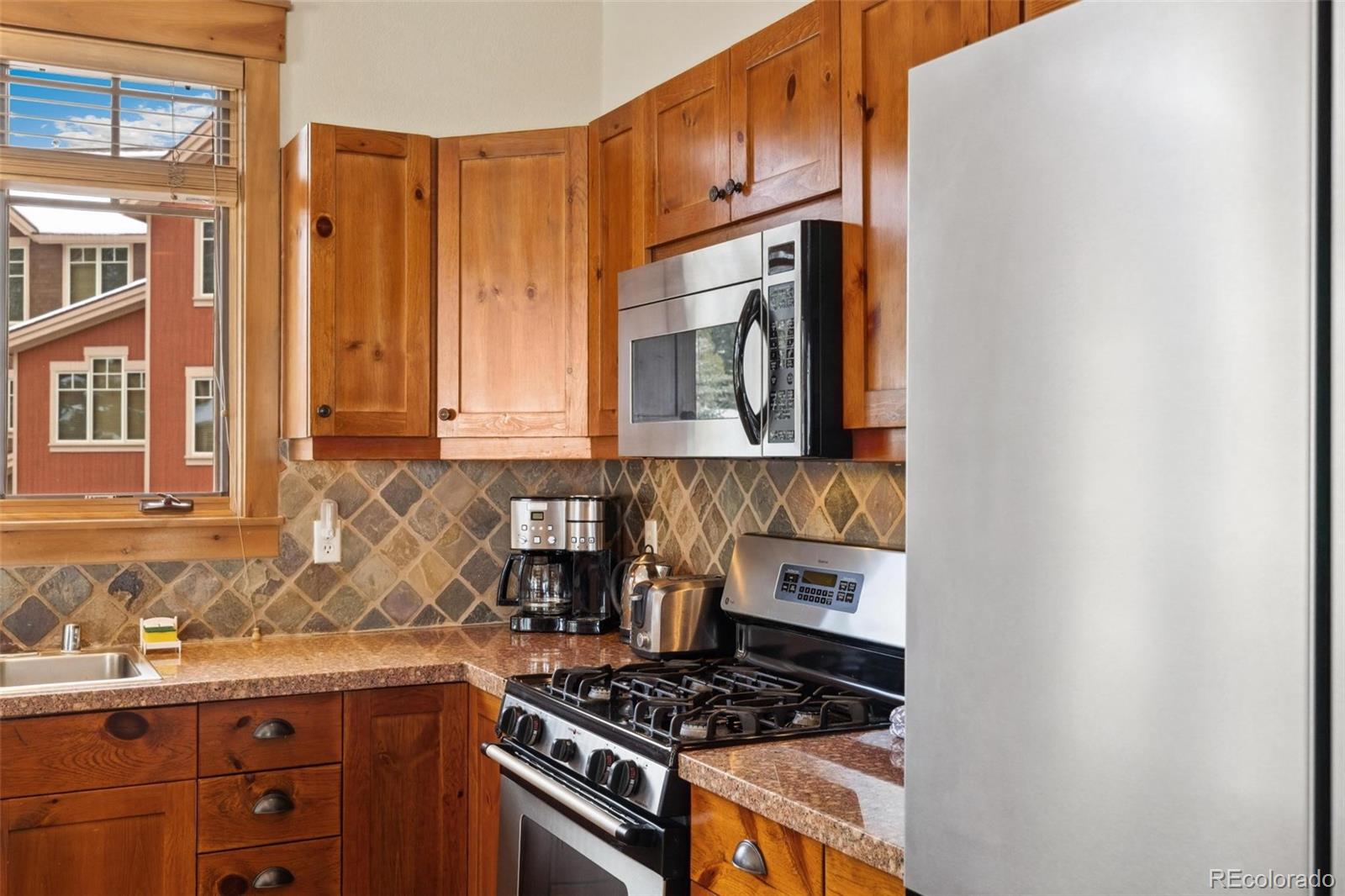 129 Tip Top Trail, Unit 6543 Dillon, CO 80435 - Photo 10 of 40 a kitchen with stainless steel appliances granite countertop a stove and a sink