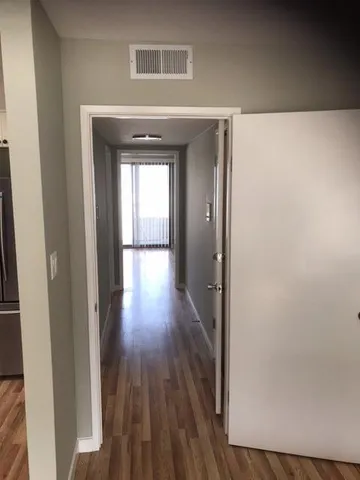 a view of a hallway with wooden floor