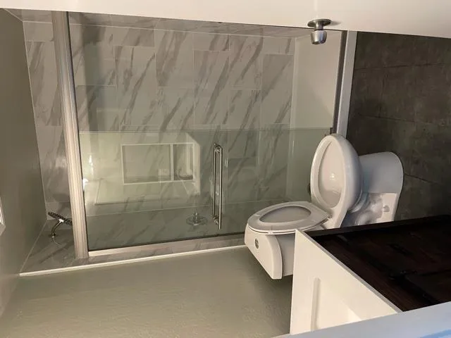 a bathroom with a sink a toilet and shower