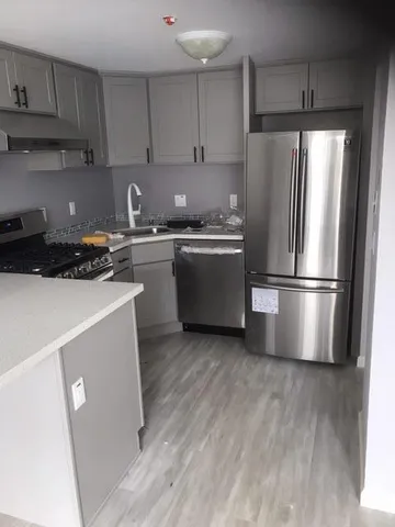 a kitchen with a refrigerator sink and cabinets