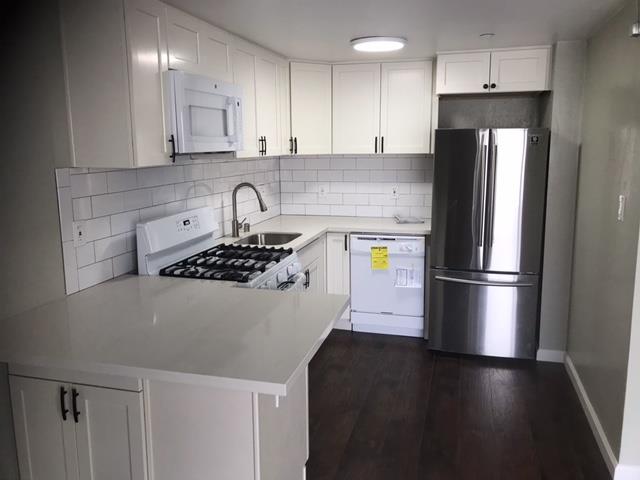 28 Houston Street San Francisco, CA 94133 - Photo 8 of 32 a kitchen with stainless steel appliances granite countertop a refrigerator a stove a sink and a microwave