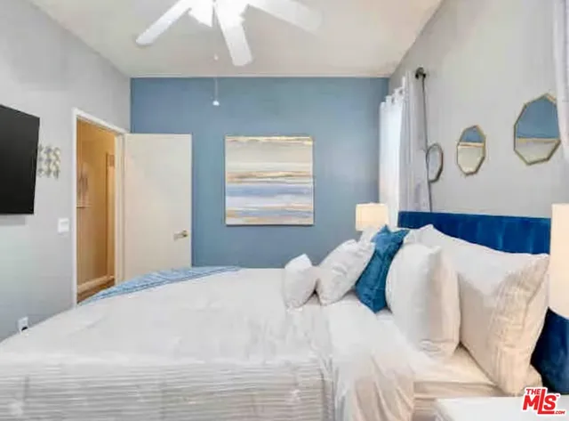 a bedroom with a bed and painting on the wall