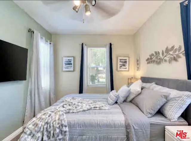 a bedroom with a large bed and a flat screen tv