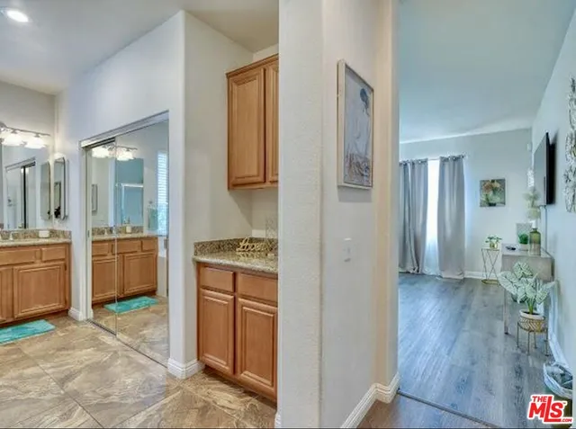 a kitchen with granite countertop a refrigerator and a stove top oven