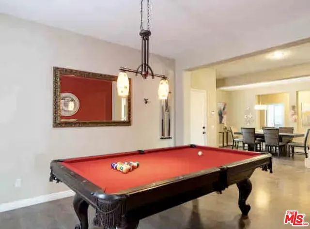 a room with pool table and windows