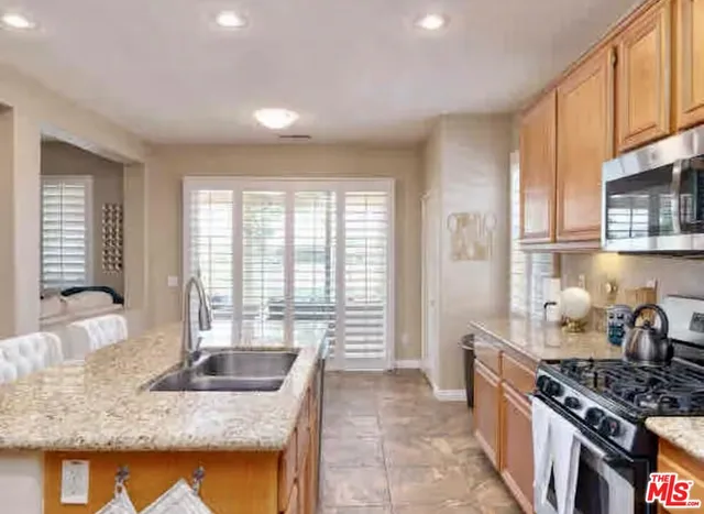 a kitchen with stainless steel appliances granite countertop a stove a sink and a refrigerator