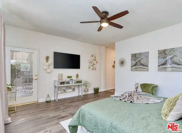 a bedroom with a bed tv and a window