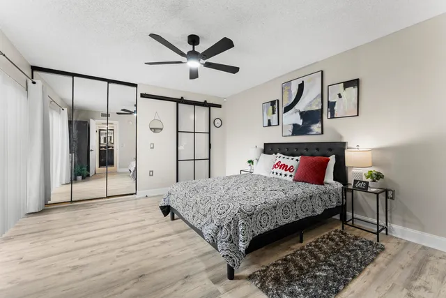 a bedroom with a large bed and a chandelier