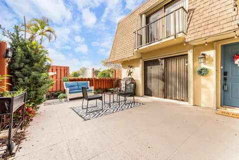 a view of a patio with a table and chairs and potted plants