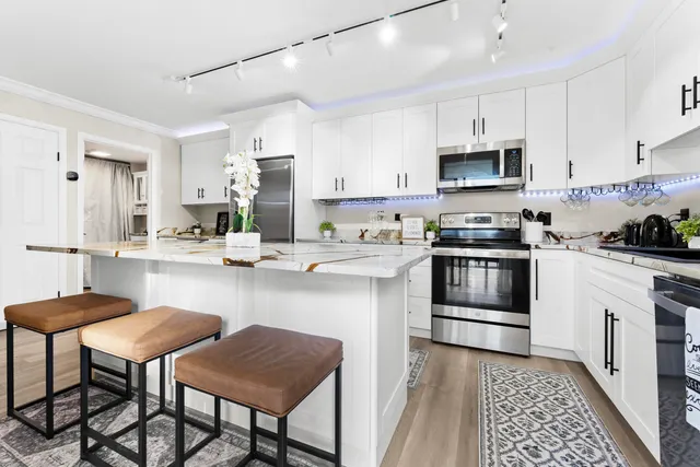 a kitchen with stainless steel appliances kitchen island granite countertop a sink and cabinets