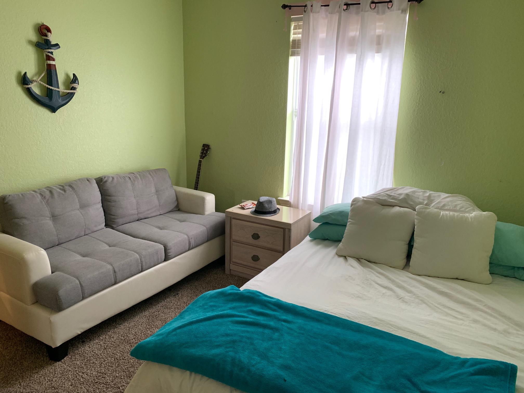 1014 Airport Road, Unit 114 Destin, FL 32541 - Photo 12 of 15 a bedroom with a bed couch and window