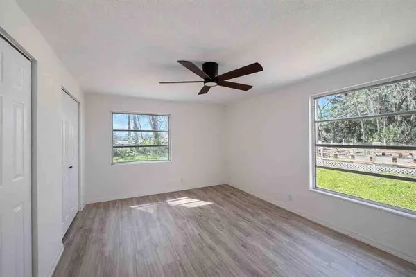 a view of room with window ceiling fan and hardwood floor