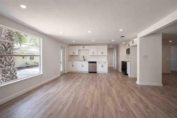 a view of a kitchen with wooden floor and a window