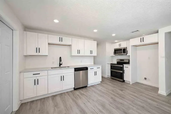 a kitchen with stainless steel appliances a refrigerator sink and cabinets
