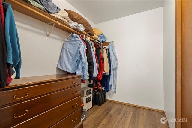 a view of walk in closet with clothes and shoes