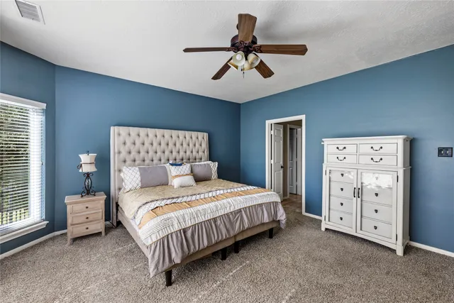 a bedroom with a bed and a large window