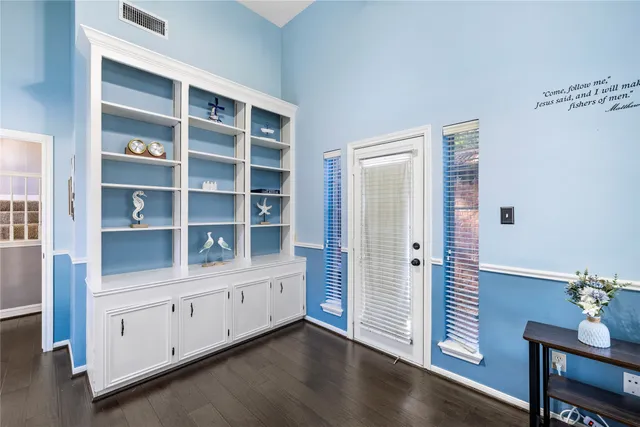 a front view of a house with a yard and large trees