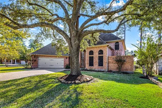 a front view of a house with a yard and trees