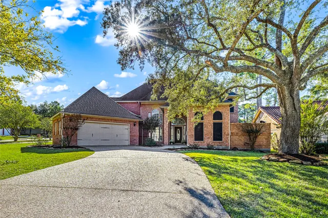 a front view of a house with a garden and trees