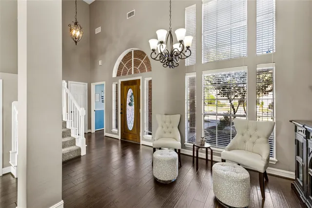 a kitchen with stainless steel appliances granite countertop a sink dishwasher a stove and a refrigerator with wooden floor