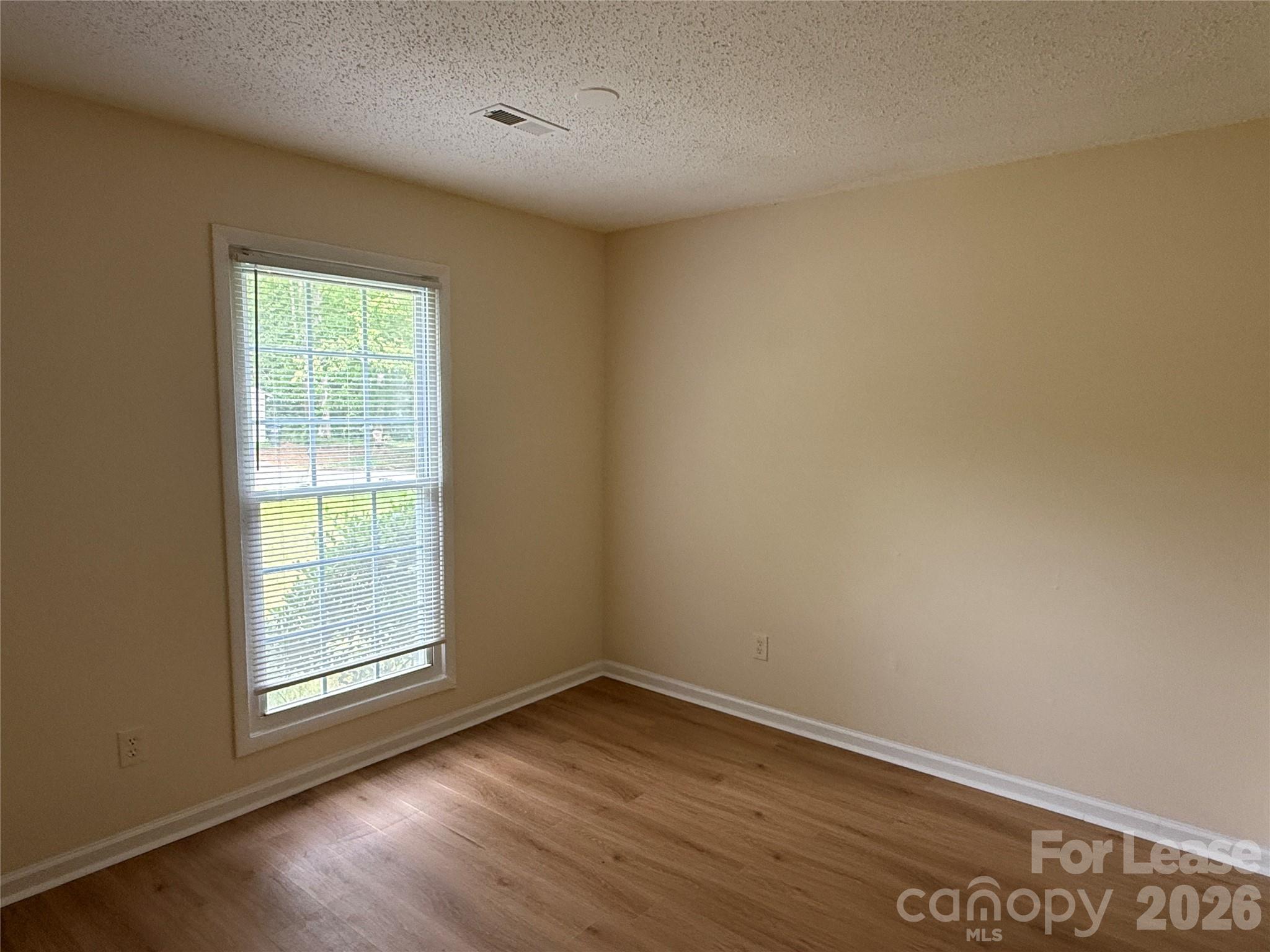 6341 Round Hill Road Charlotte, NC 28211 - Photo 9 of 16 an empty room with wooden floor and windows