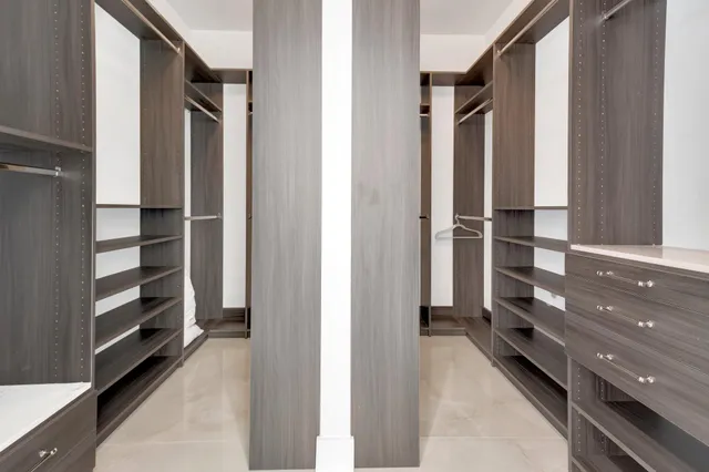 a view of walk in closet and empty room