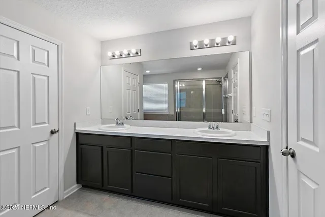 a bathroom with a double vanity sink and a mirror