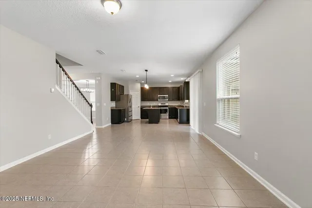 a view of an empty room with a kitchen