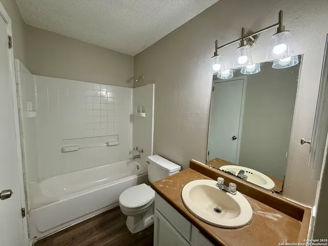 a bathroom with a sink toilet mirror and shower