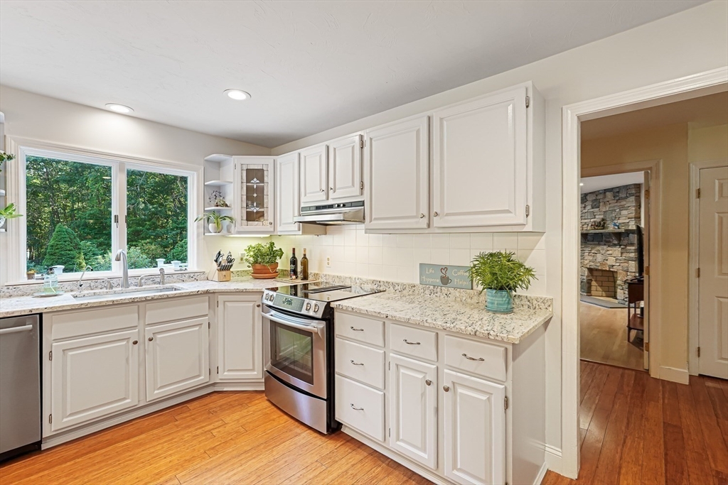33 Woodstone Road Northborough, MA 01532 - Photo 12 of 42 a kitchen with stainless steel appliances granite countertop a stove a sink and white cabinets with wooden floor