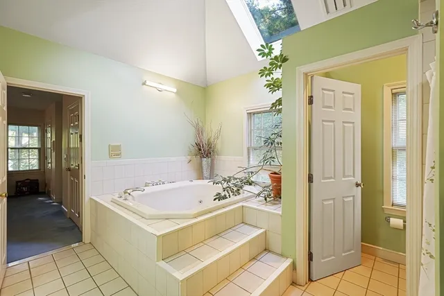 a bathroom with a tub a sink and a mirror