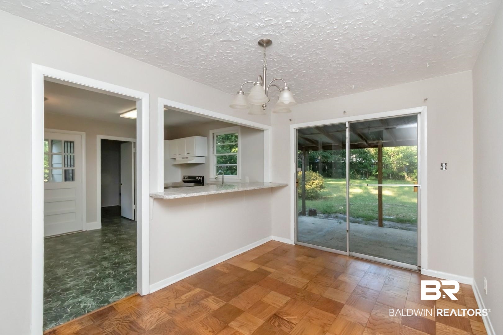 1220 Garland Drive Mobile, AL 36618 - Photo 8 of 25 Unfurnished dining area featuring parquet flooring, sink, an inviting chandelier, and a textured ceiling