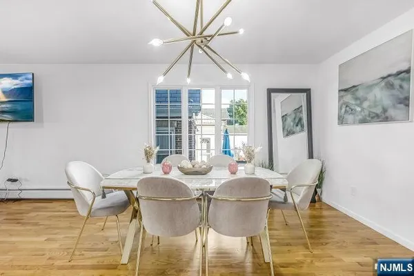 a dining room with furniture a chandelier and wooden floor