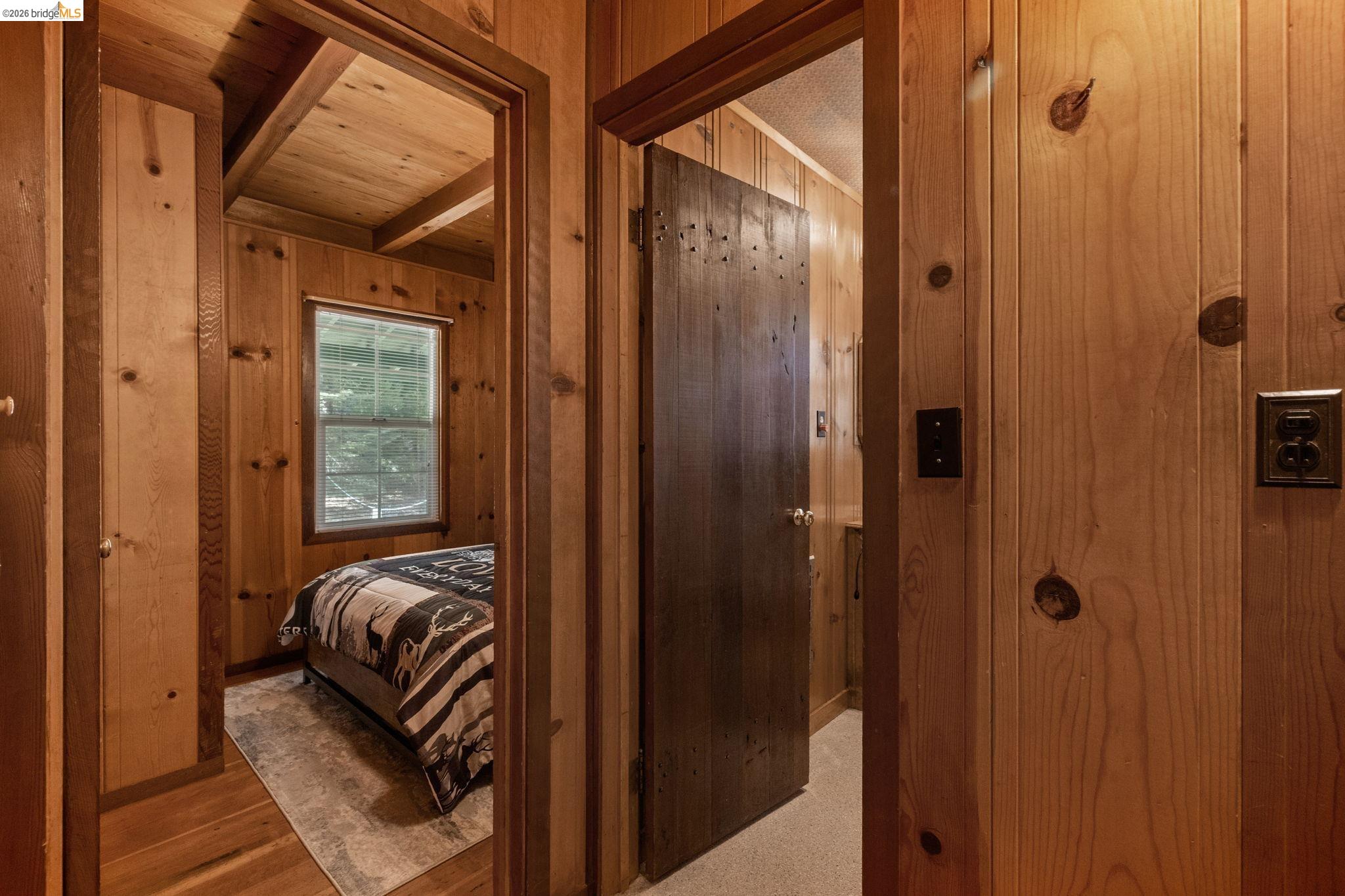 26175 Janice Way Long Barn, CA 95335 - Photo 12 of 23 Bedroom with wood walls, a wooden ceiling with exposed beams, and wood finished floors