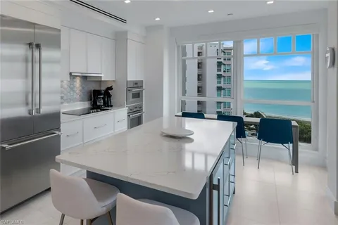 a kitchen with a table chairs refrigerator and cabinets
