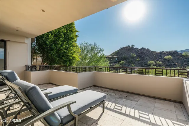 a balcony with wooden floor and outdoor seating