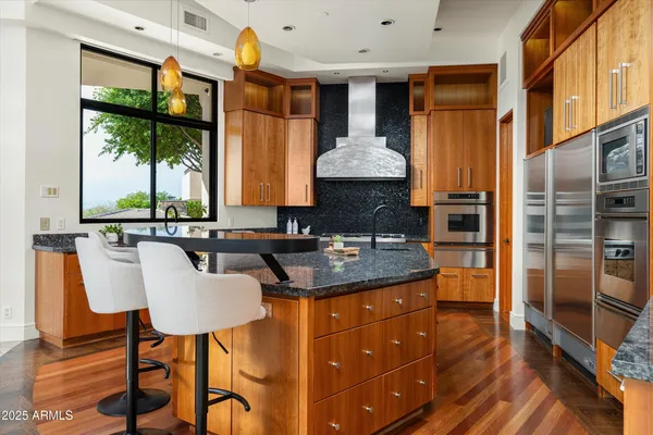 a kitchen with kitchen island granite countertop a sink a counter top space and living room view