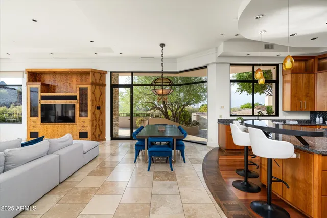 a kitchen with kitchen island granite countertop a sink a counter top space and living room view