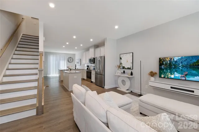 a living room with kitchen island furniture and a flat screen tv